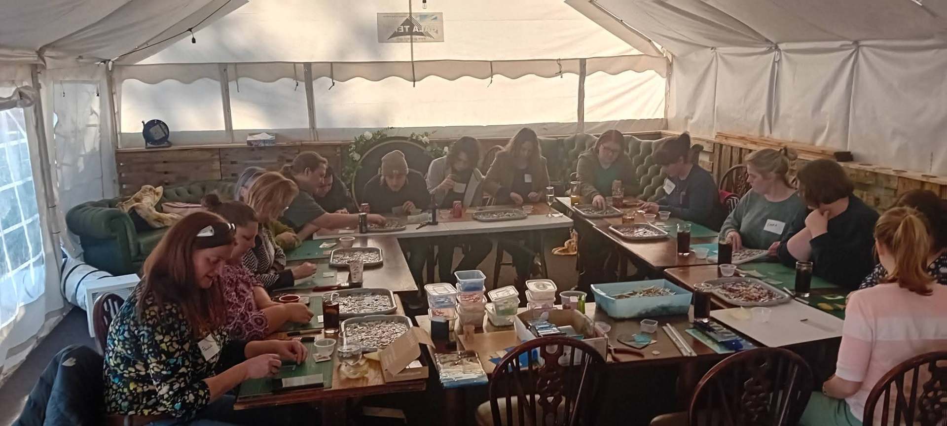 A full marquee of participants working on glass mosaic projects together