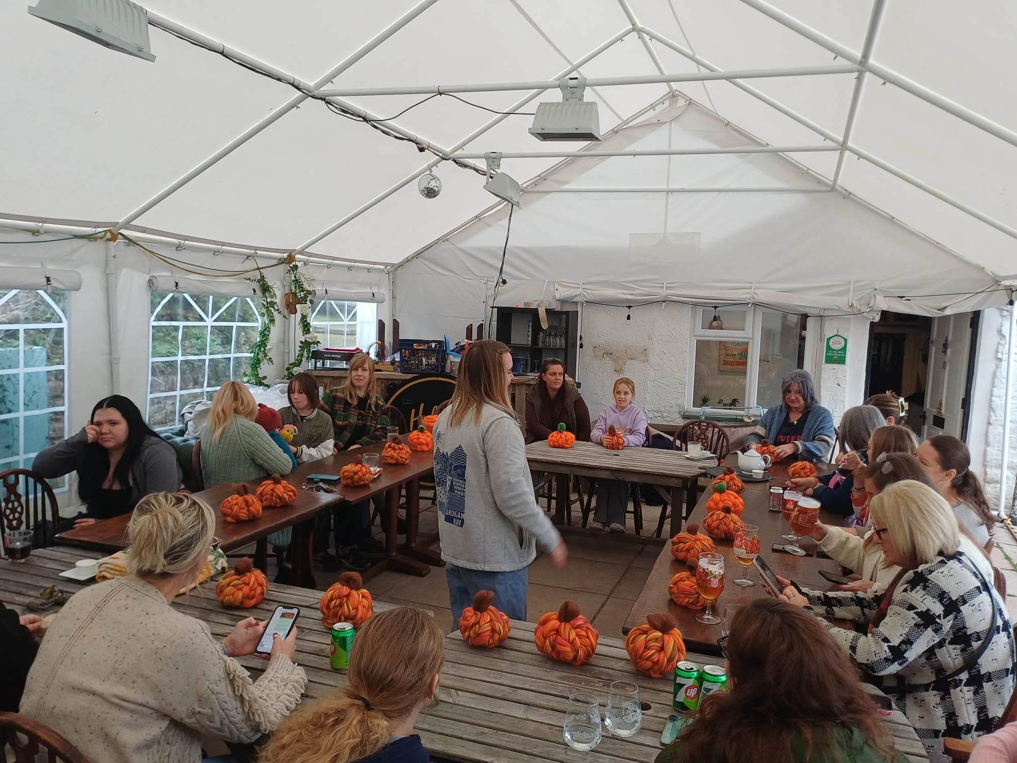 Group around long tables at a chunky-wool pumpkin workshop in the marquee